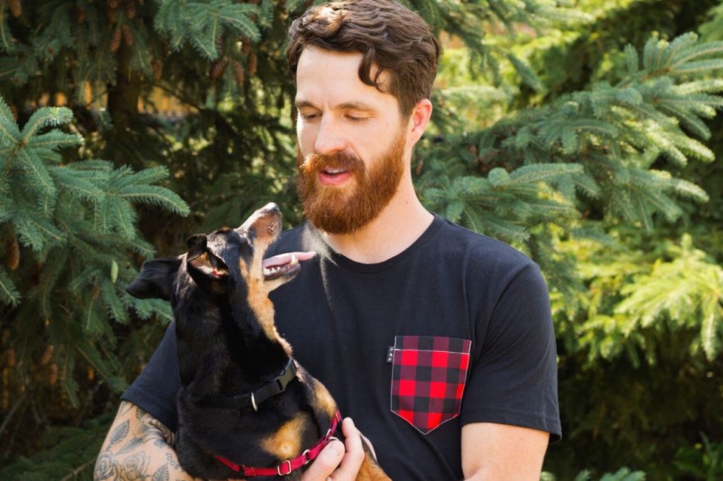 A dog owner holds their beloved canine companion, sharing a meaningful gaze during an in-home private training session, illustrating the personalized and attentive services offered by our dog training program.